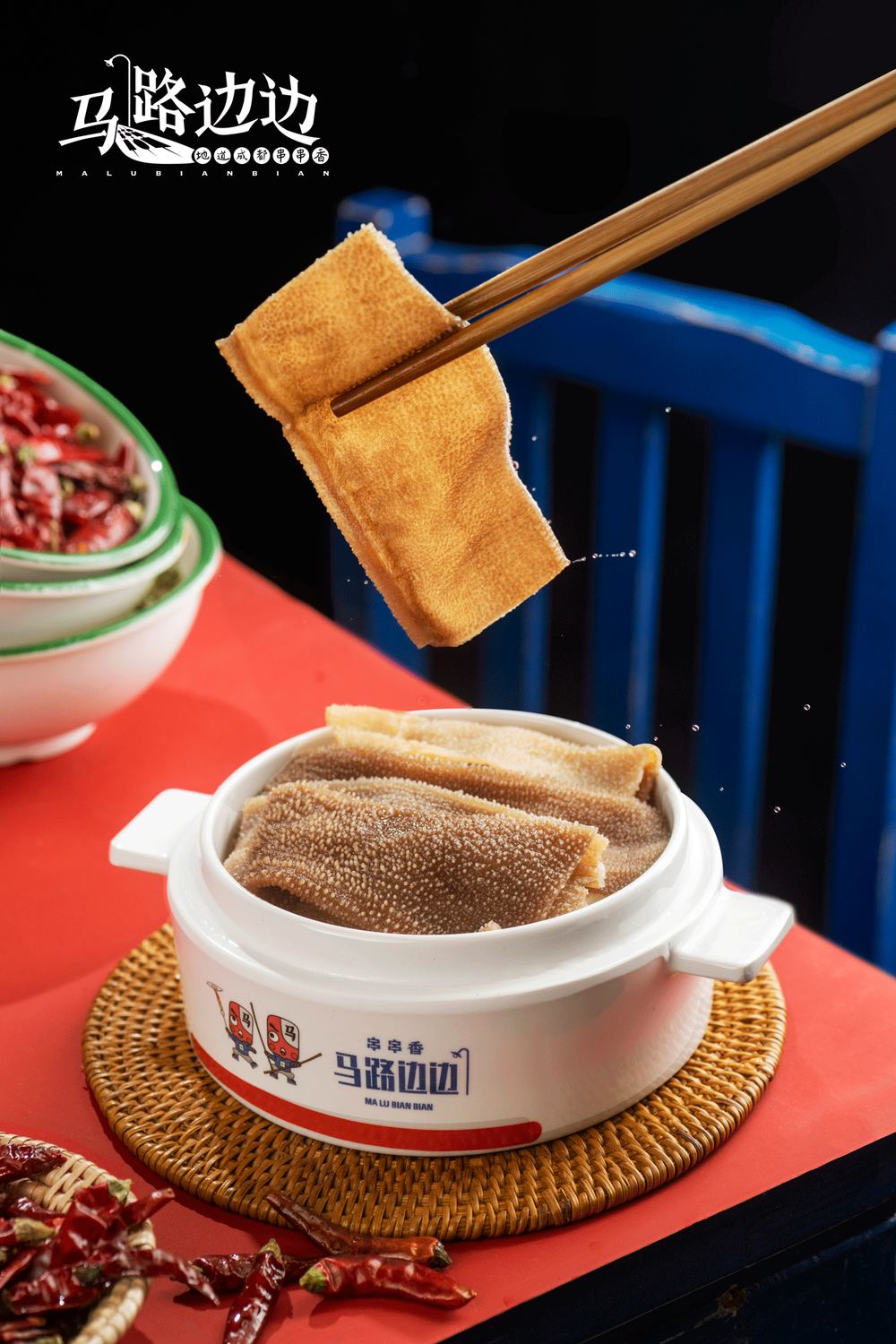 Beef tripe lifted by chopsticks over a Ma Lu Bian Bian pot